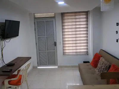 a living room with a couch and a television at Hermoso aparta estudio en Medellin in Medellín