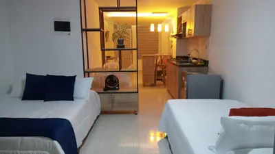a small room with two beds and a kitchen at Hermoso aparta estudio en Medellin in Medellín