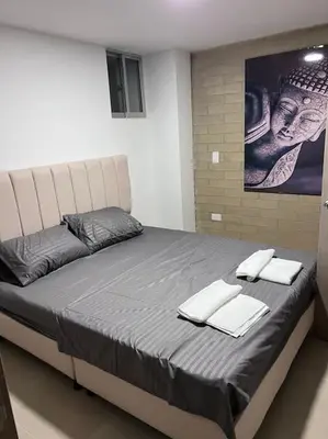 a bedroom with a large bed with towels on it at Apartamento en maravilloso Laureles con piscina 801 in Medellín