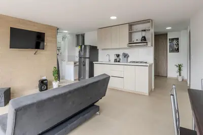 a living room with a couch and a kitchen at Apartamento en maravilloso Laureles con piscina 801 in Medellín