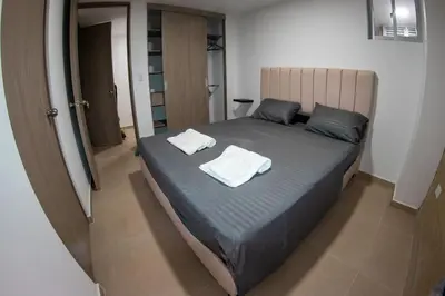 a bedroom with a bed with two towels on it at Apartamento en maravilloso Laureles con piscina 801 in Medellín