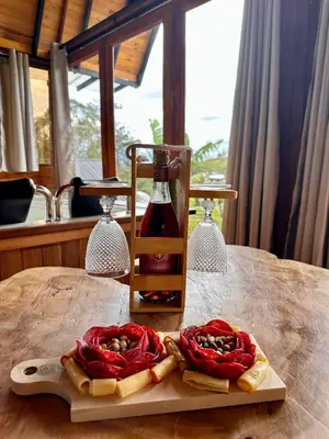 a table with a bottle of wine and some food at Ecoedén glamping in Guatapé