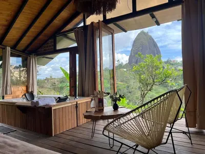 a room with a hammock and a view of a mountain at Ecoedén glamping in Guatapé