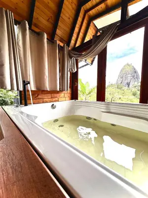 a bath tub in a room with a window at Ecoedén glamping in Guatapé