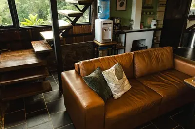 a brown leather couch with two pillows on it at Refined cabin, panoramic views, steps from Jericó in Jericó