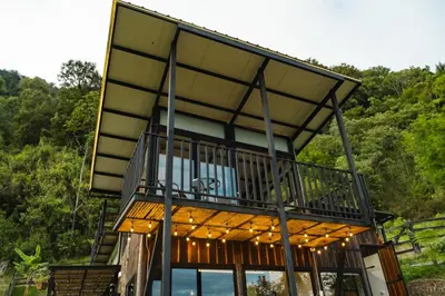 a house with a balcony with lights on it at Refined cabin, panoramic views, steps from Jericó in Jericó