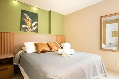 a bedroom with a large bed with a mirror at ApartaSuite moderno. Gran Vista. in Medellín