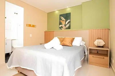 a bedroom with a large white bed and a lamp at ApartaSuite moderno. Gran Vista. in Medellín
