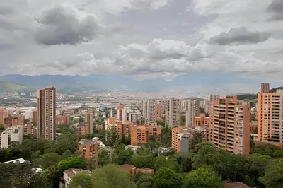 a city with tall buildings and mountains in the background at ApartaSuite moderno. Gran Vista. in Medellín