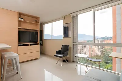 a living room with a television and a table and chairs at ApartaSuite moderno. Gran Vista. in Medellín