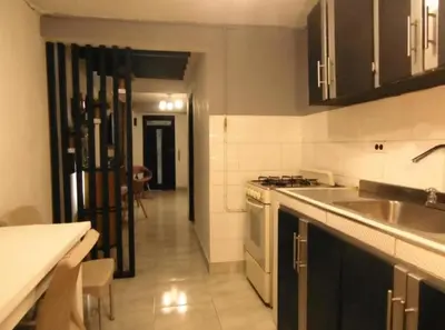 a kitchen with a sink and a stove top oven at Hospedaje J&L in Medellín