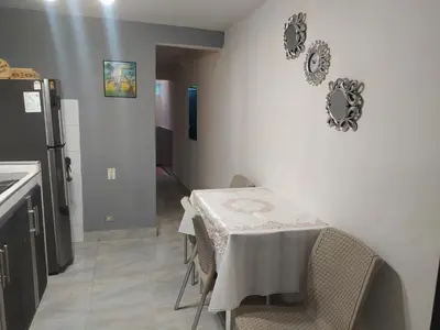 a kitchen with a table and a refrigerator at Hospedaje J&L in Medellín