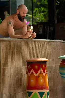 a man in a bath tub holding a glass of wine at Eco Hotel El Acuario in San Jerónimo