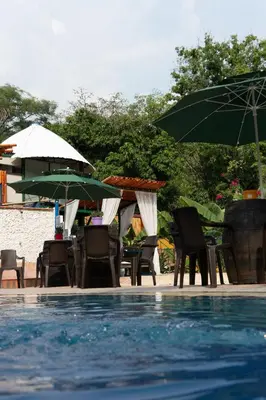 a group of chairs and umbrellas next to a swimming pool at Eco Hotel El Acuario in San Jerónimo