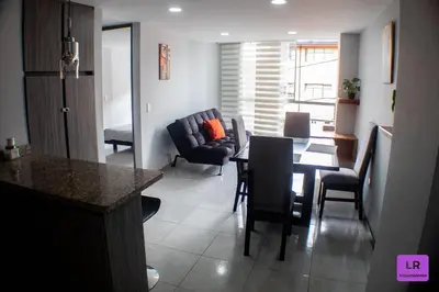a kitchen and living room with a table and chairs at Apartamento Lujoso y Nuevo en Milán in Manizales