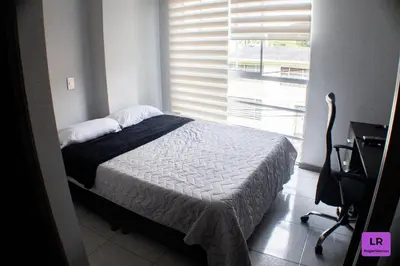 a bedroom with a bed and a window and a desk at Apartamento Lujoso y Nuevo en Milán in Manizales