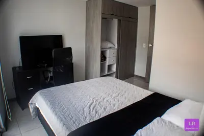 a small bedroom with a bed and a television at Apartamento Lujoso y Nuevo en Milán in Manizales
