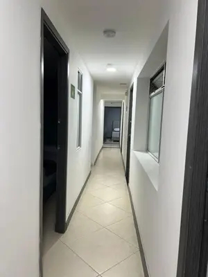 a hallway with white walls and a door and a tile floor at Hotel Casa Florida 70 Medellin in Medellín