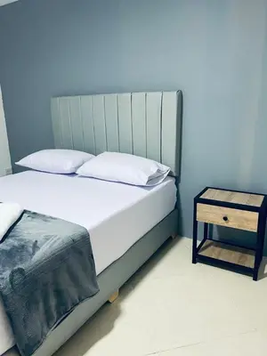 a bedroom with a bed and a side table at Hotel Casa Florida 70 Medellin in Medellín