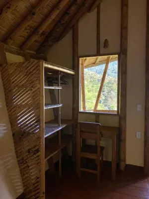 a room with a table and a chair and a window at Macuá, Refugio del bosque in San Rafael