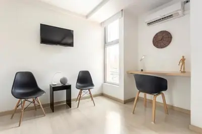a living room with two chairs and a table at San Peter Aparta Suite en La 70 Laureles in Medellín