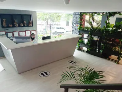 a woman standing at a counter in a store at San Peter Aparta Suite en La 70 Laureles in Medellín