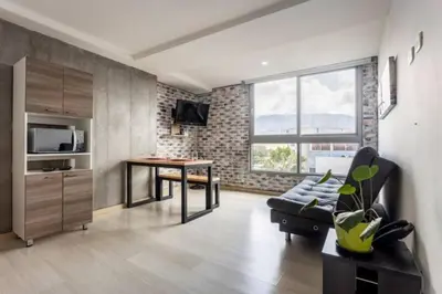 a living room with a couch and a table at San Peter Aparta Suite en La 70 Laureles in Medellín