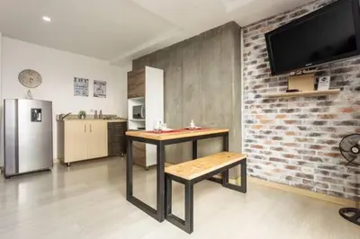 a kitchen with a table and a brick wall at San Peter Aparta Suite en La 70 Laureles in Medellín