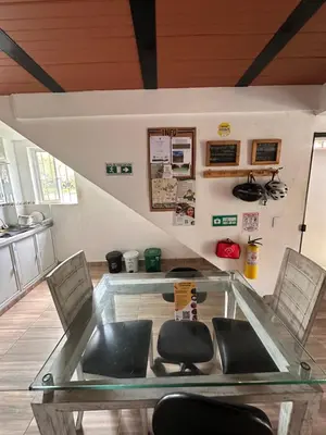 a glass table with two chairs in a room at Maracuya Hostel in San Rafael