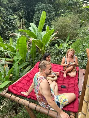 a group of people sitting on a large bed at Maracuya Hostel in San Rafael