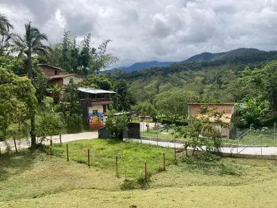 a fence in front of a house with mountains in the background at Maracuya Hostel in San Rafael
