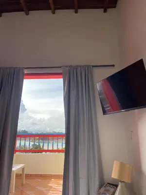 a room with a window with a view of a building at apartamento duplex con balcon y vista a la represa in Guatapé