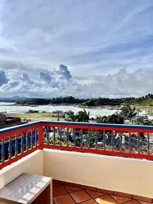 a balcony with a bench and a view of the water at apartamento duplex con balcon y vista a la represa in Guatapé