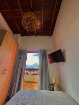 a bedroom with a bed and a large window at apartamento duplex con balcon y vista a la represa in Guatapé