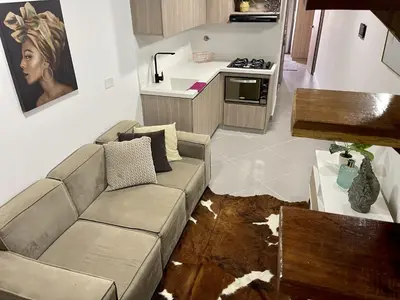 a living room with a couch and a kitchen at apartamento duplex con balcon y vista a la represa in Guatapé