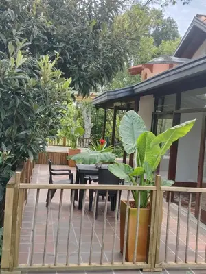 a patio with a table and chairs and trees at Hermosa Villa La Laja Rionegro in Rionegro