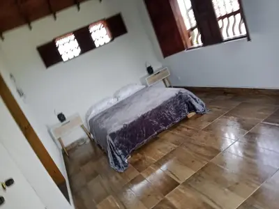 a bedroom with a bed in a room with windows at Hermosa Villa La Laja Rionegro in Rionegro