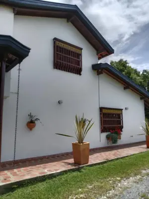 a white house with two windows and potted plants at Hermosa Villa La Laja Rionegro in Rionegro