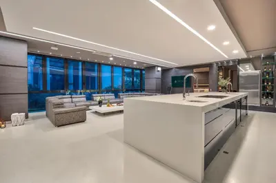 a kitchen with a sink and a living room at Europa Suites Medellin in Medellín
