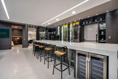 a bar with stools at a counter in a building at Europa Suites Medellin in Medellín