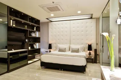 a bedroom with a king sized bed and a desk at Europa Suites Medellin in Medellín