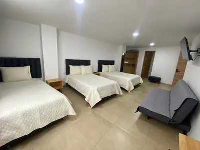 a hotel room with two beds and a chair at BISÁU Hotel in Ruiosucio