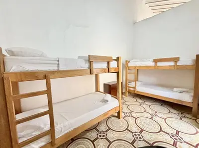 a room with three bunk beds and a rug at Casa colonial - Jacuzzi - cerca al parque principal - lundry - Tv in Santa Fe de Antioquia