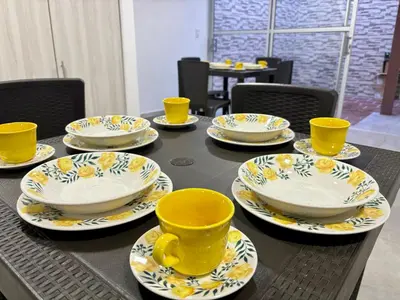 a table with yellow cups and saucers on it at Casa colonial - Jacuzzi - cerca al parque principal - lundry - Tv in Santa Fe de Antioquia