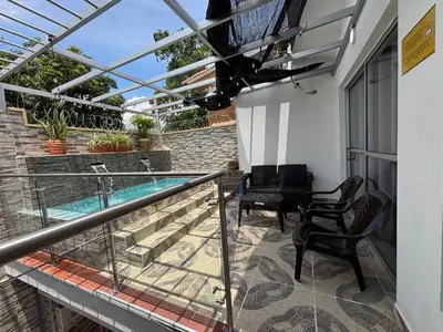 a balcony with two chairs and a swimming pool at Casa colonial - Jacuzzi - cerca al parque principal - lundry - Tv in Santa Fe de Antioquia