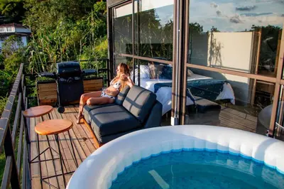 a woman sitting in a chair next to a swimming pool at Eco Lodge Glamping in Guatapé