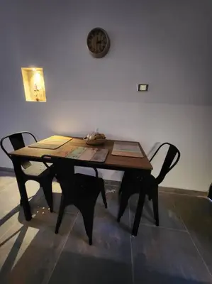 a wooden table with two chairs and a clock on the wall at Apartaestudio en El Poblado in Medellín