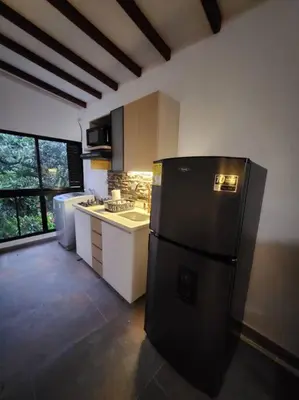 a kitchen with a black refrigerator in a room at Apartaestudio en El Poblado in Medellín