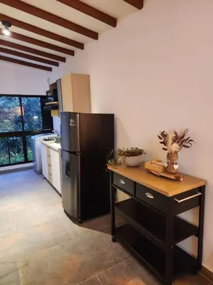 a kitchen with a black refrigerator and a table at Apartaestudio en El Poblado in Medellín