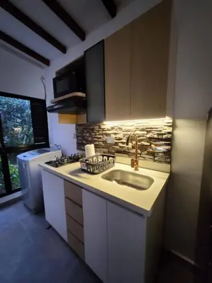 a kitchen with a sink and a stove and a refrigerator at Apartaestudio en El Poblado in Medellín